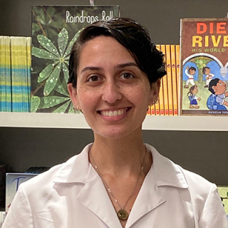 Staff member smiling for photo in white-collard shirt.