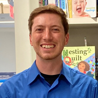 Staff member smiling for photo in blue shirt. 