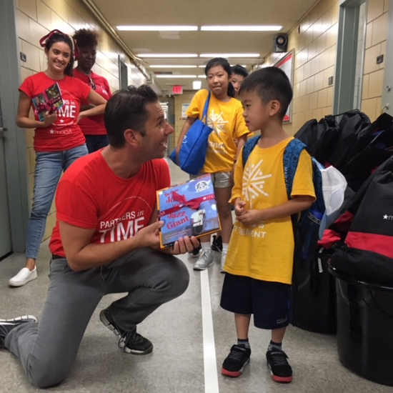 Macy's employee giving book to child - Partner with RIF