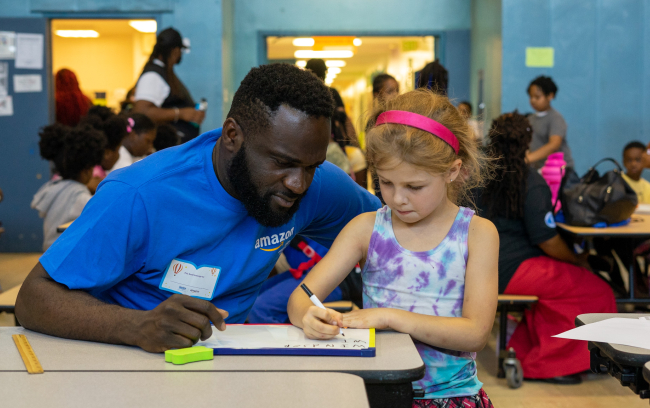 Amazon employee literacy activity with Reading Is Fundamental volunteer